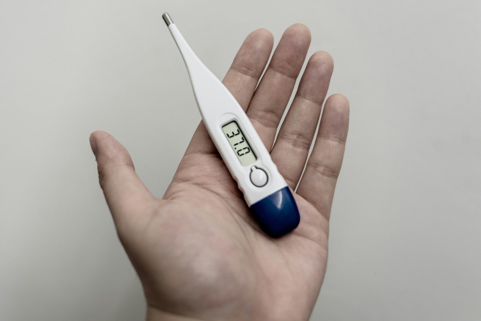 Digital thermometer resting in an open hand