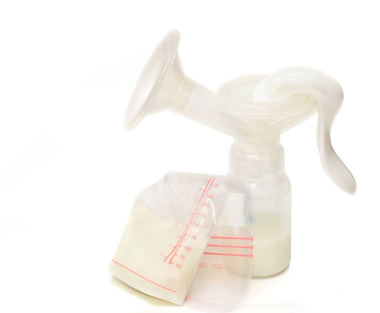 Manual breast pump with a bottle of pumped milk and a filled breast milk storage bag