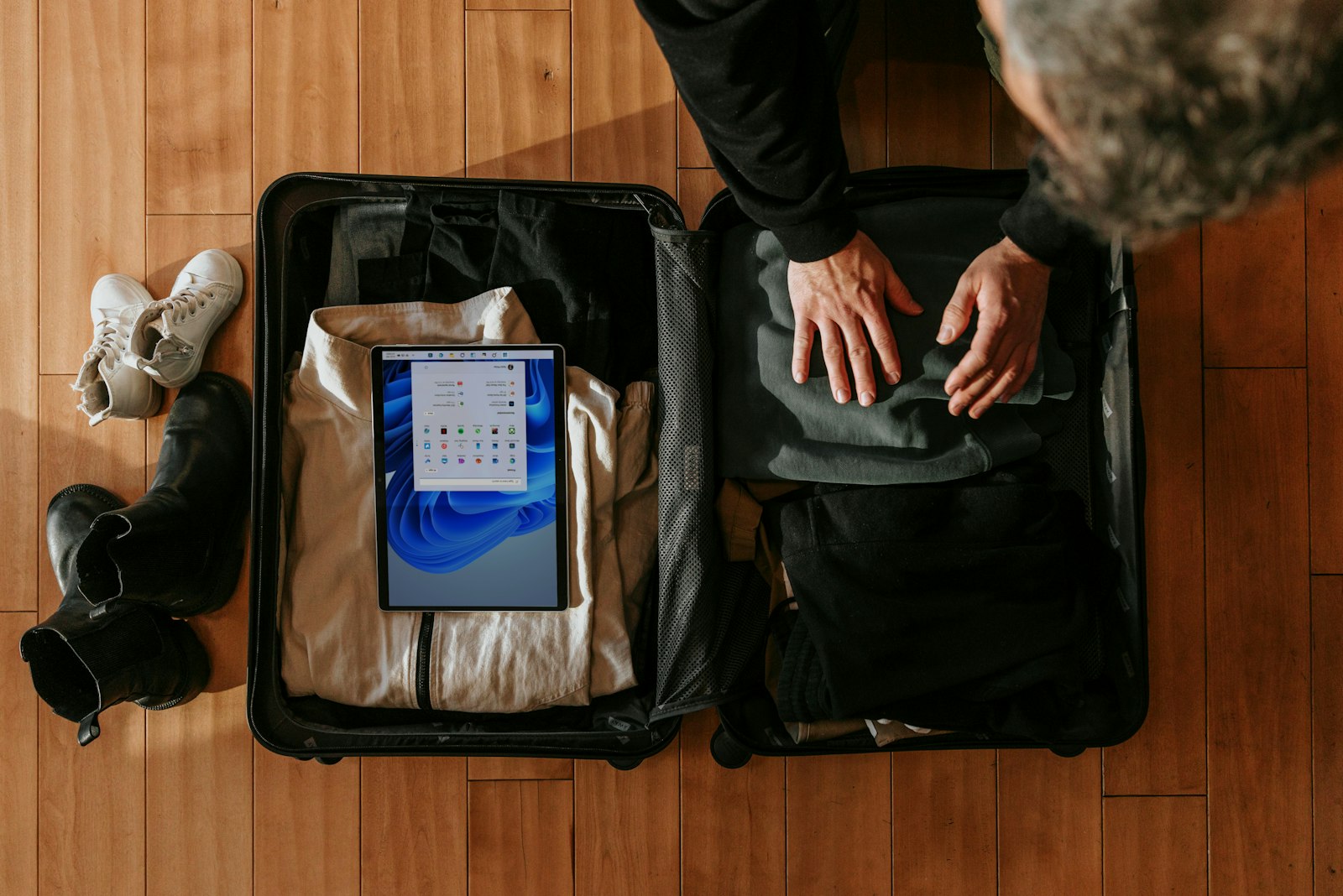 Overhead view of a person packing clothes into a suitcase